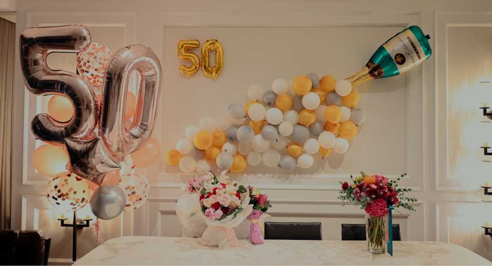 "50th "50th birthday party games table decoration with silver and gold number 50 balloons and champagne balloon arrangement"