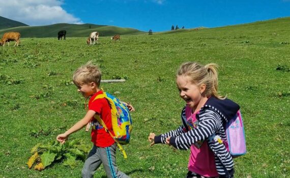 [Uber En="summer*scavenger*hunt*with*two*children*running*joyfully*across*an*alpine*meadow" De="Sommer-Schnitzeljagd*mit*zwei*Kindern,*die*fröhlich*über*eine*Alpenwiese*rennen"]